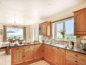una cocina con armarios de madera y una gran ventana en 4 Bed in Denbigh 62368, en Denbigh