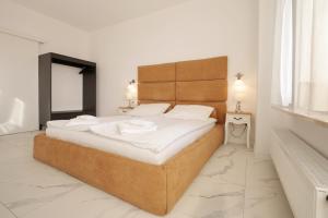 um quarto com uma cama grande e lençóis brancos em Onyx by Baltic Home em Międzyzdroje