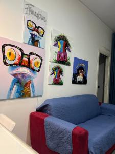 ein Wohnzimmer mit einem blauen Sofa und Bildern an der Wand in der Unterkunft Napoli, Casa di Jo appartamento al Vomero in Neapel