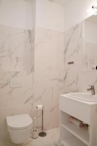 uma casa de banho branca com um WC e um lavatório em Onyx by Baltic Home em Międzyzdroje