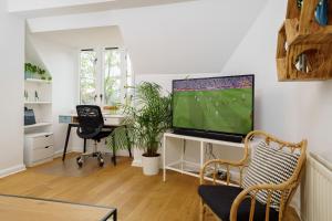 uma sala de estar com uma televisão de ecrã plano na parede em Lovely Apartment in Victoria Park Village em Londres