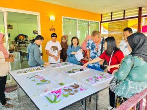 a group of people standing around a table with cakes at Banhalawee in Ko Yao Yai