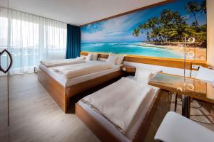 ein Schlafzimmer mit 2 Betten und ein Gemälde des Strandes in der Unterkunft Apartments in Erding - Oberbayern 36757 in Erding