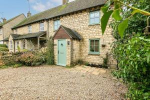 an old brick house with a green door at Stunning 3BD Oxfordshire Cottage in Enstone in Enstone