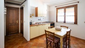 a kitchen with a table and chairs in a room at Meraviglioso bilocale a 700metri dalla spiaggia in Cala Liberotto