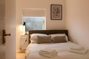 a bedroom with a bed with two towels on it at Stunning 3BD Oxfordshire Cottage in Enstone in Enstone
