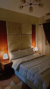 a bedroom with a large bed and two lamps at Solima pyramids inn in Cairo
