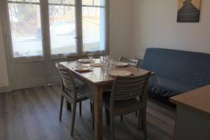 einem Esstisch mit Stühlen, einem Tisch und einem Sofa in der Unterkunft Ronce-les-Bains - APPARTEMENT REZ-DE-CHAUSSÉE droit - 90m de la PLAGE in Ronce-les-Bains