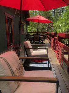 un patio con mesas, sillas y sombrillas rojas en Read Haven 3 Bedroom, 1.5 Bath, en Twain Harte