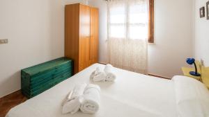 a room with a bed with towels on it at Meraviglioso bilocale a 700metri dalla spiaggia in Cala Liberotto