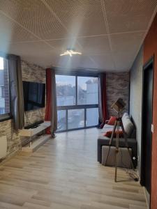 - un salon avec un canapé et une télévision dans l'établissement Cosy Loft - Calais, à Calais