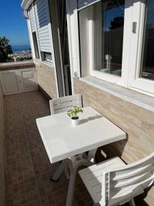 een witte tafel en 2 stoelen op een balkon bij camera vista mare in Anacapri