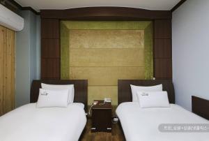 dos camas sentadas una al lado de la otra en una habitación en Hyatt Motel en Suncheon