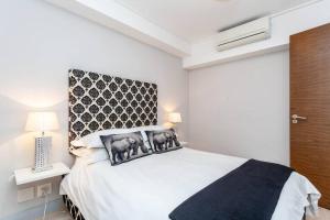 a bedroom with a large white bed with a headboard at Waterfront Canal Luxury Apartment in Cape Town +25 photos