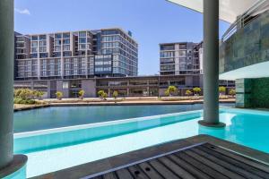 an empty swimming pool with buildings in the background at Executive 1 Bedroom in Canal Quays in Cape Town