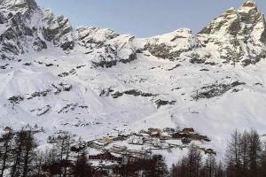 a snow covered mountain with a house in front of it at Casa a Cervinia sulle piste in Breuil-Cervinia