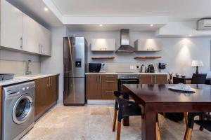 a kitchen with a dining table and a refrigerator at Executive 1 Bedroom in Canal Quays in Cape Town