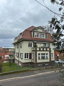 uma grande casa branca com um telhado vermelho em Ferienwohnung Eisenach Süd em Eisenach