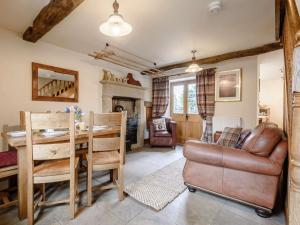 a living room with a table and a leather chair at 3 Bed in Hartington 54215 in Hartington