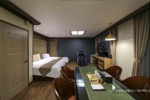 a hotel room with a bed and a table and chairs at Hyatt Motel in Suncheon