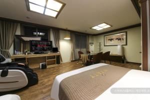 ein Hotelzimmer mit einem Bett und einem Flachbild-TV in der Unterkunft Hyatt Motel in Suncheon