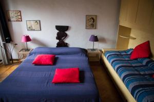 ローマにあるTrastevere Maus Roomsの赤い枕が備わる客室内のベッド2台