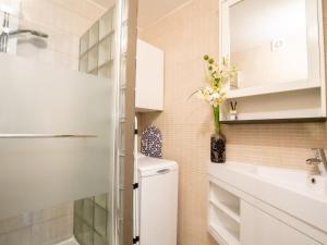 a bathroom with a sink and a toilet and a mirror at Apartment Giuliott with parking and shared pool by Interhome in De Haan