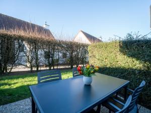 a table with a vase of flowers on it at Apartment Giuliott with parking and shared pool by Interhome in De Haan