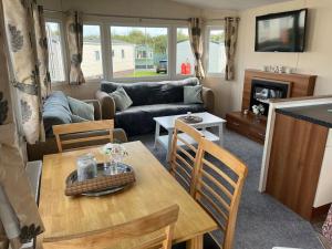 a living room with a table and a couch at Beautiful Seaside Holiday Home Sleeps 6 in Heysham