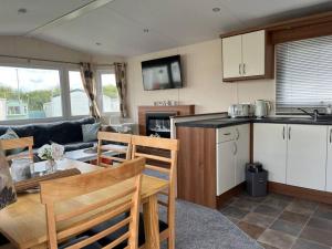 a kitchen and living room with a table and chairs at Beautiful Seaside Holiday Home Sleeps 6 in Heysham