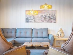 sala de estar con sofá azul y mesa en Holiday Home Teerenpesue a 5 by Interhome, en Saariselkä