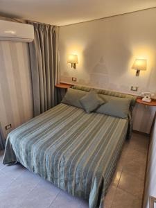 a bedroom with a bed with a striped comforter at Hotel Pacific in Rome