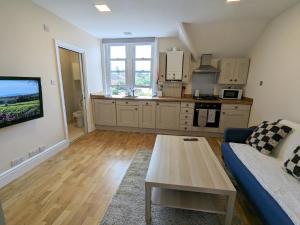 a living room with a couch and a kitchen at Guildford Station with Parking in Stoughton