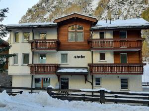 ein großes Gebäude mit Holzbalkonen im Schnee in der Unterkunft Apartment Alpin Smile by Interhome in Saas-Almagell