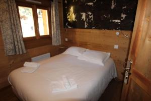 um quarto com uma cama com lençóis brancos e toalhas em Chalet Nobel Centre ville 8 pers - 4 Chambres - 4 SdB em Font-Romeu