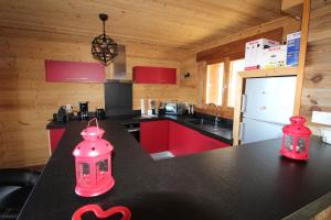 uma cozinha com armários vermelhos e um balcão preto em Chalet Nobel Centre ville 8 pers - 4 Chambres - 4 SdB em Font-Romeu