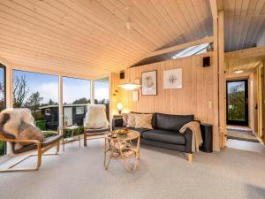 uma sala de estar com um sofá, cadeiras e janelas em Holiday Home Diuri - 300m to the inlet in The Liim Fiord by Interhome em Struer
