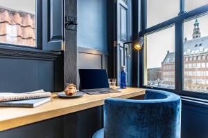 a desk with a laptop and a blue chair at CTY Books in Leiden