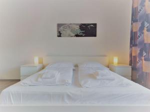 1 dormitorio con 1 cama blanca y 2 almohadas en Apartment Landhaus St- Georg-2 by Interhome, en Bad Gastein