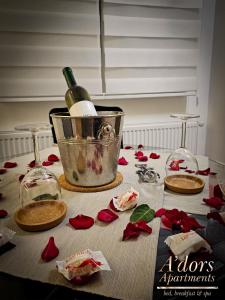 斯科普里的住宿－A'dors Apartments - Bed, Breakfast & Spa，一张带玫瑰的桌子和一瓶葡萄酒及眼镜