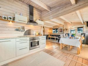 cocina y comedor con mesa y fogones en Holiday Home Joar - 11km from the sea in Western Jutland by Interhome, en Oksbøl