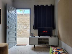 uma porta para um quarto com uma televisão numa cómoda em Lugarzin2 - Casa Privada - Garagem Compartilhada em Vitória da Conquista