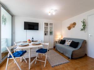 uma sala de estar com uma mesa e um sofá em Apartment Les Maisons sur la Plage-12 by Interhome em Narbonne Plage