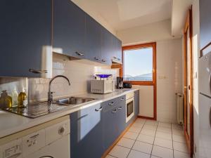 cocina con armarios azules, fregadero y ventana en Appartement Hendaye, 2 pièces, 6 personnes - FR-1-2-350, en Hendaya