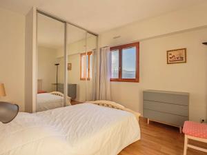 1 dormitorio con cama blanca y espejo en Appartement Hendaye, 2 pièces, 6 personnes - FR-1-2-350, en Hendaya