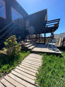 a house with a wooden walkway leading to a deck at Cabaña con tinaja a pasos de la playa in Boca Pupuya