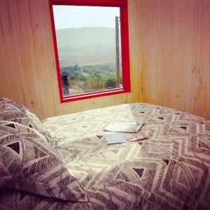 a bed in a room with a window at Cabaña con tinaja a pasos de la playa in Boca Pupuya