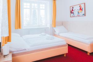2 camas en una habitación con ventana en Kavárna a penzion REICHL, en Králíky