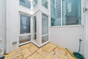 an empty room with windows and a hose at Lovely Mews House Royal Crescent in London