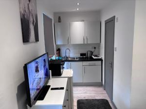 a kitchen with a flat screen tv on a counter at Romford Cosy Studio Flat in Havering atte Bower